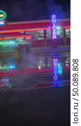 Neon reflection on wet pavement near retro diner at night captures urban atmosphere. Стоковое AI-видео, аниматор Владимир Федоров / Фотобанк Лори