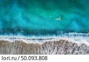 Aerial view of swimming woman in mediterranean sea in Oludeniz, Turkey. Beautiful summer seascape with girl, clear azure water, waves and sandy beach in sunny day. Top view from flying drone. Nature. Aerial view of swimming woman in mediterranean sea . Стоковое фото, агентство Ingram Publishing / Фотобанк Лори