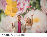 Свадебное торжество с женихом и невестой на фоне цветущих роз и воздушных шаров. Стоковое AI-изображение, AI-художник Сергей Никифоров-Гордеев / Фотобанк Лори