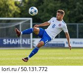 A soccer player in a blue and white uniform kicks a soccer ball. Стоковое AI-изображение, AI-художник Ярославский Максим / Фотобанк Лори