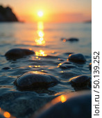 As dawn breaks, vibrant hues brighten the horizon while smooth stones glisten in the tranquil waters, creating a serene coastal atmosphere of peace and reflection Generative AI. Стоковое AI-изображение, AI-художник Юлия Петровская / Фотобанк Лори
