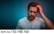Middleaged man in pain against blue background. Стоковое AI-изображение, AI-художник Андрей Бакусов / Фотобанк Лори