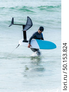 A middle aged man is finishing some foil surfing or hydrofoil surf training in the sea. Стоковое фото, агентство Ingram Publishing / Фотобанк Лори