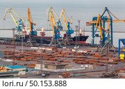 Sea commercial port at night in Mariupol, Ukraine. Industrial view. Cargo freight ship with working cranes bridge in sea port at twilight. Cargo port, logistic. Стоковое фото, агентство Ingram Publishing / Фотобанк Лори