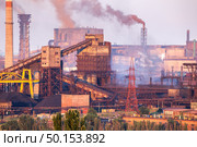 Industrial landscape in Ukraine. Steel factory with smog at sunset. Pipes with smoke. Metallurgical plant. steelworks, iron works. Heavy industry. Ecology problems, atmospheric pollutants. Стоковое фото, агентство Ingram Publishing / Фотобанк Лори