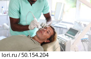 Adult man undergoing device-driven cosmetic facial treatment using high frequency ultrasound attachment stimulating opening of skin pores for deep penetration of moisturizers and nutrients. Стоковое видео, видеограф Яков Филимонов / Фотобанк Лори
