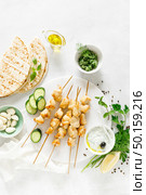 Grilled chicken kebab on skewers and traditional Greek tzatziki yogurt sauce, tview from above. Стоковое фото, агентство Ingram Publishing / Фотобанк Лори