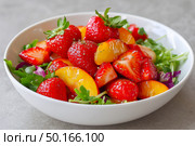 Fresh salad featuring vibrant strawberries, peaches, and mixed greens, elegantly presented in a white bowl, showcasing colorful ingredients and healthy eating lifestyle. Стоковое AI-изображение, AI-художник Ирина Ручушкина / Фотобанк Лори