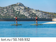 Stand up paddleboarding on lake. Watersport on lake. Tourist outdoor activity at Lagoa Comprida, Serra da Estrela National Park in Portugal. Стоковое фото, агентство Ingram Publishing / Фотобанк Лори