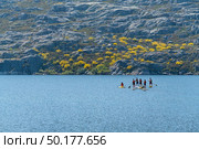 Stand up paddleboarding on lake. Watersport on lake. Tourist outdoor activity at Lagoa Comprida, Serra da Estrela National Park in Portugal. Стоковое фото, агентство Ingram Publishing / Фотобанк Лори