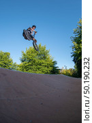 Biker jump high from jump box ramp performing dangerous 360 trick. Стоковое фото, агентство Ingram Publishing / Фотобанк Лори