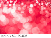 Red bokeh holiday textured Christmas decorations background. Стоковое фото, агентство Ingram Publishing / Фотобанк Лори