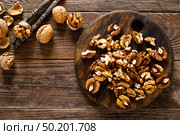 Walnuts. Kernels and whole nuts on wooden rustic table, top view. Стоковое фото, агентство Ingram Publishing / Фотобанк Лори