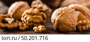 Walnuts. Kernels and whole nuts on wooden rustic table closeup, banner. Стоковое фото, агентство Ingram Publishing / Фотобанк Лори