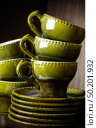 Old vintage cracked glaze tea coffee set. Retro pottery ceramics set cups and saucers autumn green colors background. Стоковое фото, фотограф Camptoloma / Фотобанк Лори