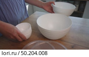 Woman reviewing plastic food storage containers with clear lids. Стоковое видео, видеограф Vadzim Yakubovich / Фотобанк Лори