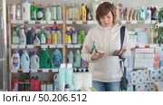 Store visitor woman purchases in household chemicals department, choose eye shadow pallet. Стоковое видео, видеограф Яков Филимонов / Фотобанк Лори