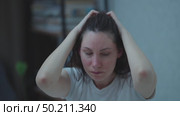 A young adult woman sits on a couch in the middle of the night, nervously twirling her hair. Panic attacks and mental health. Стоковое видео, видеограф Денис Кебедов / Фотобанк Лори