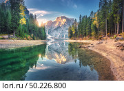 Amazing Braies lake at sunrise in autumn in Dolomites, Italy. Landscape with mountains, blue sky with clouds, water with reflection, trees with colorful leaves. Lake in fall. Italian alps. Panorama. Amazing Braies lake at sunrise in autumn in Dolomites, Italy. Стоковое фото, агентство Ingram Publishing / Фотобанк Лори