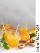 Orange juice. Freshly squeezed juice in glasses and fresh fruits with leaves. Стоковое фото, агентство Ingram Publishing / Фотобанк Лори