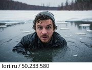 A man finds himself unexpectedly submerged in frigid waters, surrounded by floating ice. The gray winter sky looms overhead as he strives to stay afloat, embodying resilience Generative AI. Стоковое AI-изображение, AI-художник Юлия Петровская / Фотобанк Лори