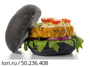 Tasty grilled veggie burger with chickpeas and vegetables on black bread on white background. Стоковое фото, агентство Ingram Publishing / Фотобанк Лори