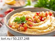 Chickpea hummus with tahini in a bowl. Healthy vegetarian appetizer. Middle Eastern cuisine. Стоковое фото, агентство Ingram Publishing / Фотобанк Лори