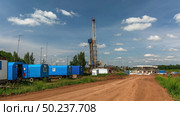 Drilling of oil wells. Residential mobile homes for drilling workers. There is a drilling rig and equipment in the background. There is a road in the foreground. Summer. Beautiful sky and nature. Стоковое фото, фотограф Владимир Ендовицкий / Фотобанк Лори