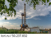 Drilling a well in an oil field. Mobile drilling rig and drilling equipment. Summer. Beautiful sky and nature. Стоковое фото, фотограф Владимир Ендовицкий / Фотобанк Лори