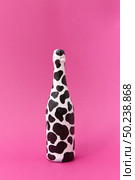 Creative white painted champagne bottle with black spots on a hot pink background, place for text. Minimalism concept.. White painted wine bottle with black spots. Стоковое фото, агентство Ingram Publishing / Фотобанк Лори
