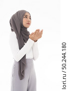 Young Adult Muslim Woman girl making Duas for Muslim god blessing prayer. Studio shot of woman isolated on white background. Стоковое фото, агентство Ingram Publishing / Фотобанк Лори
