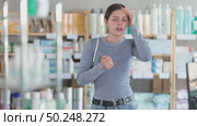 Young female client having severe headache while being in chemist's shop. Стоковое видео, видеограф Яков Филимонов / Фотобанк Лори