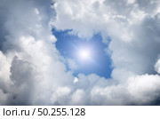 Hole in the clouds. Beautiful white clouds on blue sky with holes in the center. Стоковое фото, агентство Ingram Publishing / Фотобанк Лори