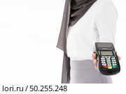 Close-up of confident happy smiling female muslim woman with EDC machine as owner merchant concept. Studio shot on white background. Using for sale consumerism and shopaholic concept. Стоковое фото, агентство Ingram Publishing / Фотобанк Лори