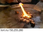 Cooking of beef teppanyaki recipe japanese grilled beef on cooking pan with scraper and gas burner flame. Стоковое фото, агентство Ingram Publishing / Фотобанк Лори