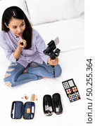 Top View young beautiful Asian woman beauty vlogger or blogger recording live how to make up tutorial to share on social media using Gimbal Stabilizer on mobile phone. Using for vlog social media influencer concept. Стоковое фото, агентство Ingram Publishing / Фотобанк Лори