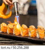 Chef cooking Salmon Foie gras roll, Fusion Japanese Cuisine food, using gas burner torch. Стоковое фото, агентство Ingram Publishing / Фотобанк Лори