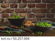 Green pea soup with linseed and pumpkin and sunflower seeds on a rustic kitchen countertop. Стоковое фото, агентство Ingram Publishing / Фотобанк Лори