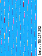 Decorative congratulation composition from multicolored bithday candles for sweet dessert on a blue background. Birthday party card.. Vertical background from pattern of burning candles for cake. Стоковое фото, агентство Ingram Publishing / Фотобанк Лори