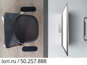 Modern comfortable workspace - computer desk with mockup white computer monitor and orthopaedic chair. Top view. Home working outside office concept.. Top view modern mock up computer screen on an office table. Стоковое фото, агентство Ingram Publishing / Фотобанк Лори