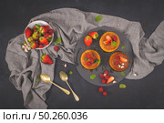 Caramel custard puddings on round slate on and dark kitchen countertop. Стоковое фото, агентство Ingram Publishing / Фотобанк Лори