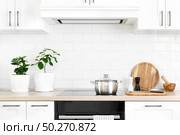 White modern kitchen interior with wooden worktop and kitchenware, culinary concept, background. Стоковое фото, агентство Ingram Publishing / Фотобанк Лори