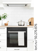 White modern kitchen interior with wooden worktop and kitchenware, culinary concept, background. Стоковое фото, агентство Ingram Publishing / Фотобанк Лори