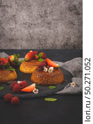 Caramel custard puddings on round slate on and dark kitchen countertop. Стоковое фото, агентство Ingram Publishing / Фотобанк Лори