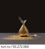 Vertically standing crashed old-fashioned aged hourglass with bits of glass and golden sand on a duotone dark background, copy space.. Brocken vintage sandglass with golden sand on a black duotone background. Стоковое фото, агентство Ingram Publishing / Фотобанк Лори