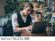Young unemployed man is looking news for a job in the laptop. Стоковое фото, агентство Ingram Publishing / Фотобанк Лори