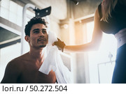 The girl uses a handkerchief to sweat the young man while exercising in the gym. Стоковое фото, агентство Ingram Publishing / Фотобанк Лори