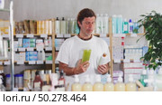 Adult man chooses a medicated shampoo for dandruff and against hair loss in a pharmacy. Buying anti-baldness shampoos. Стоковое видео, видеограф Яков Филимонов / Фотобанк Лори