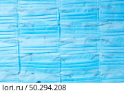 Textile medical background from antibacterial protective blue face masks. Concept of prevention from respiratory sickness and viruses.. Medical masks horizontal background. Things for protection. Top view. Стоковое фото, агентство Ingram Publishing / Фотобанк Лори