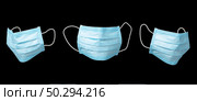 Medical set from three antibacterial protective blue face masks on a black background, copy space. Concept of prevention from respiratory sickness and viruses.. Three flying medical masks against black background. Стоковое фото, агентство Ingram Publishing / Фотобанк Лори